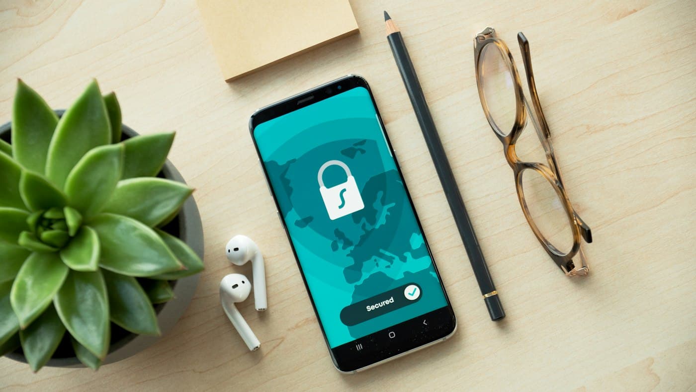 A smartphone showing a padlock security screen on a wooden desk