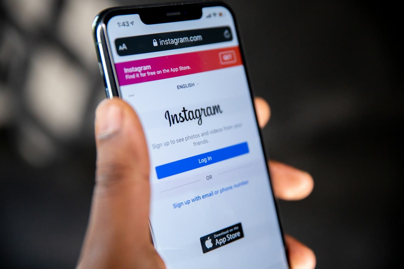 A hand holding a phone showing the Instagram app